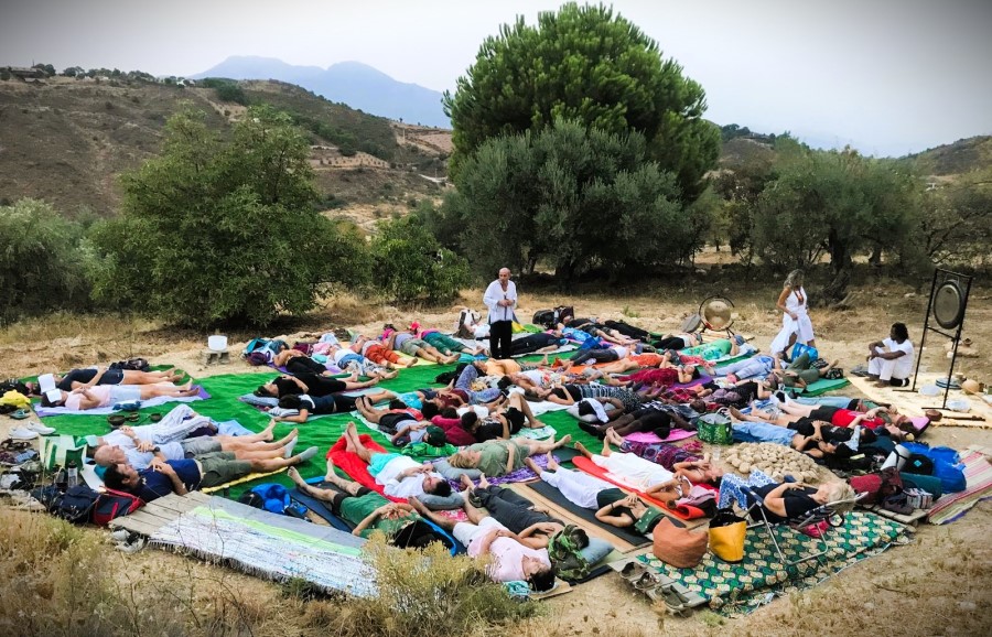 Personas tumbadas haciendo gongs en el campo guiado por Raíces Psicoterapia