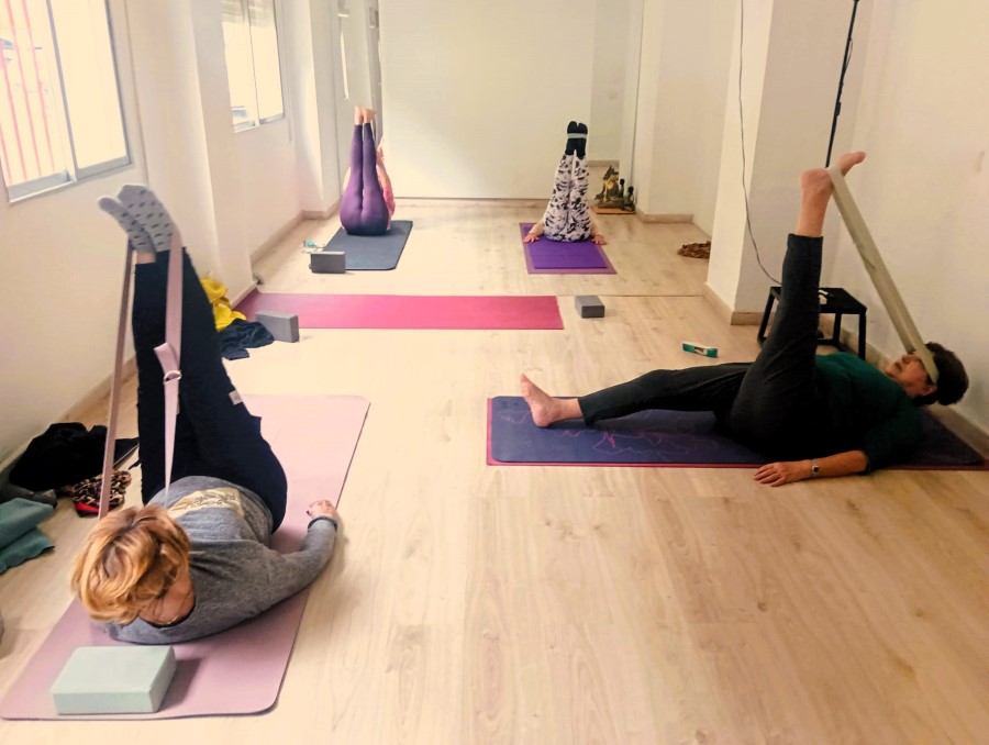 Personas haciendo yoga en la sala de Raíces Psicología